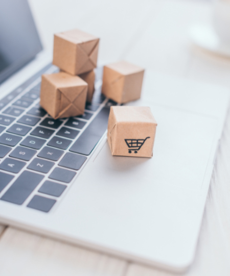 selective focus of toy paper boxes with shopping symbol on lapto